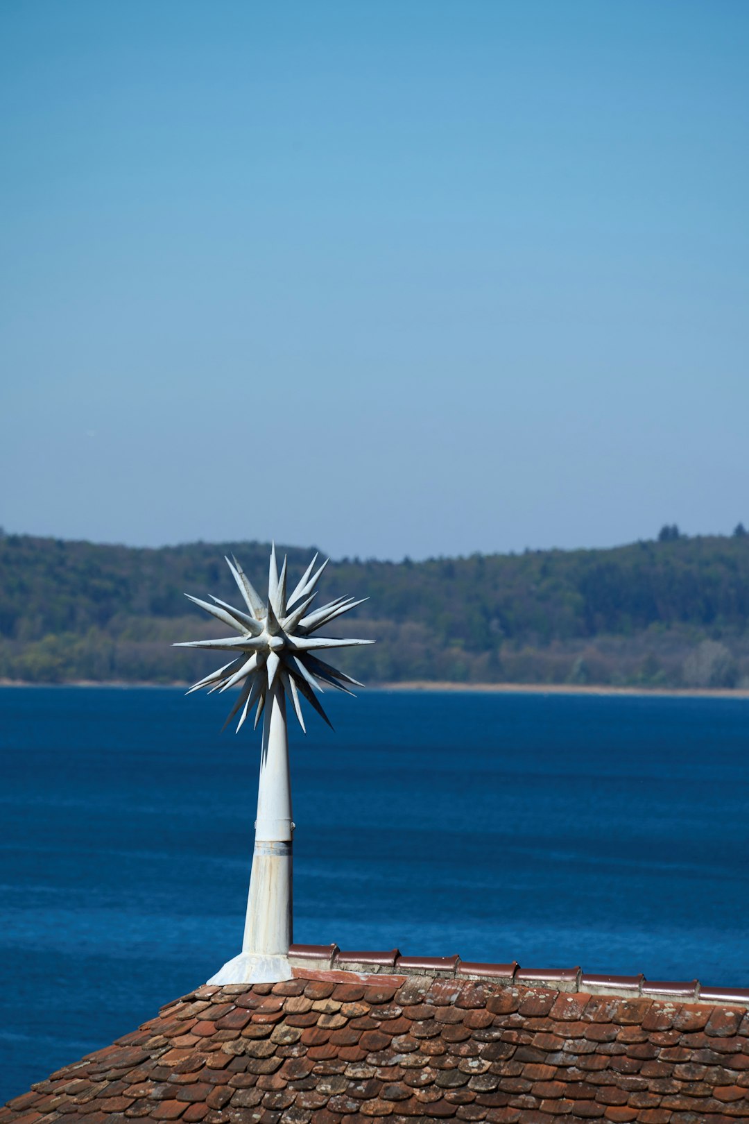 star-like-object-sits-atop-a-roof-by-a-lake-ja9gwzz7dpc